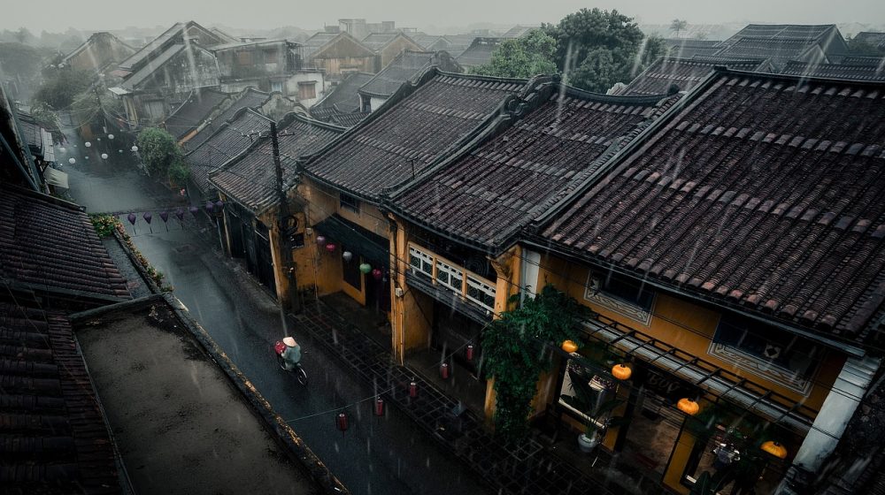 手绘风格的东方庙宇外景插画，青绿屋顶与珊瑚色灯笼，石阶前落叶散落，光线温暖柔和